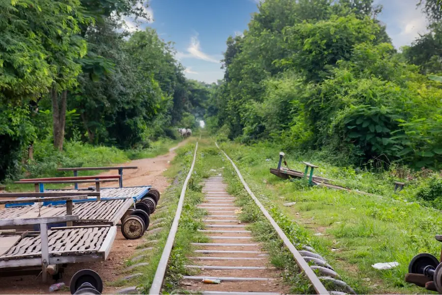 Une plateforme de train en bambou longeant la voie ferrée à travers les rizières près de Battambang