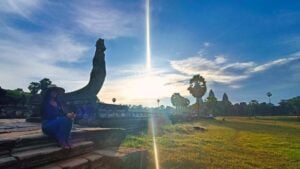 Akim Ly assis près de la balustrade naga au lever du soleil à Angkor Vat.