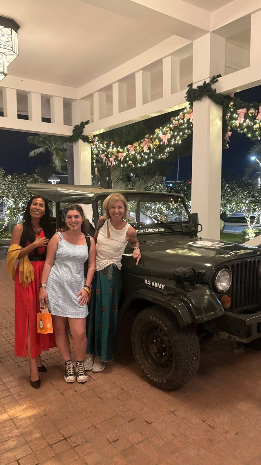 Akim Ly avec deux invités à côté d'une jeep Willys vintage le soir