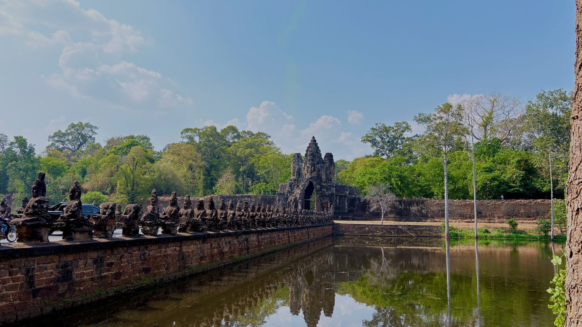 Row of asura guardian statues lining the stone causeway over the Angkor Thom moat