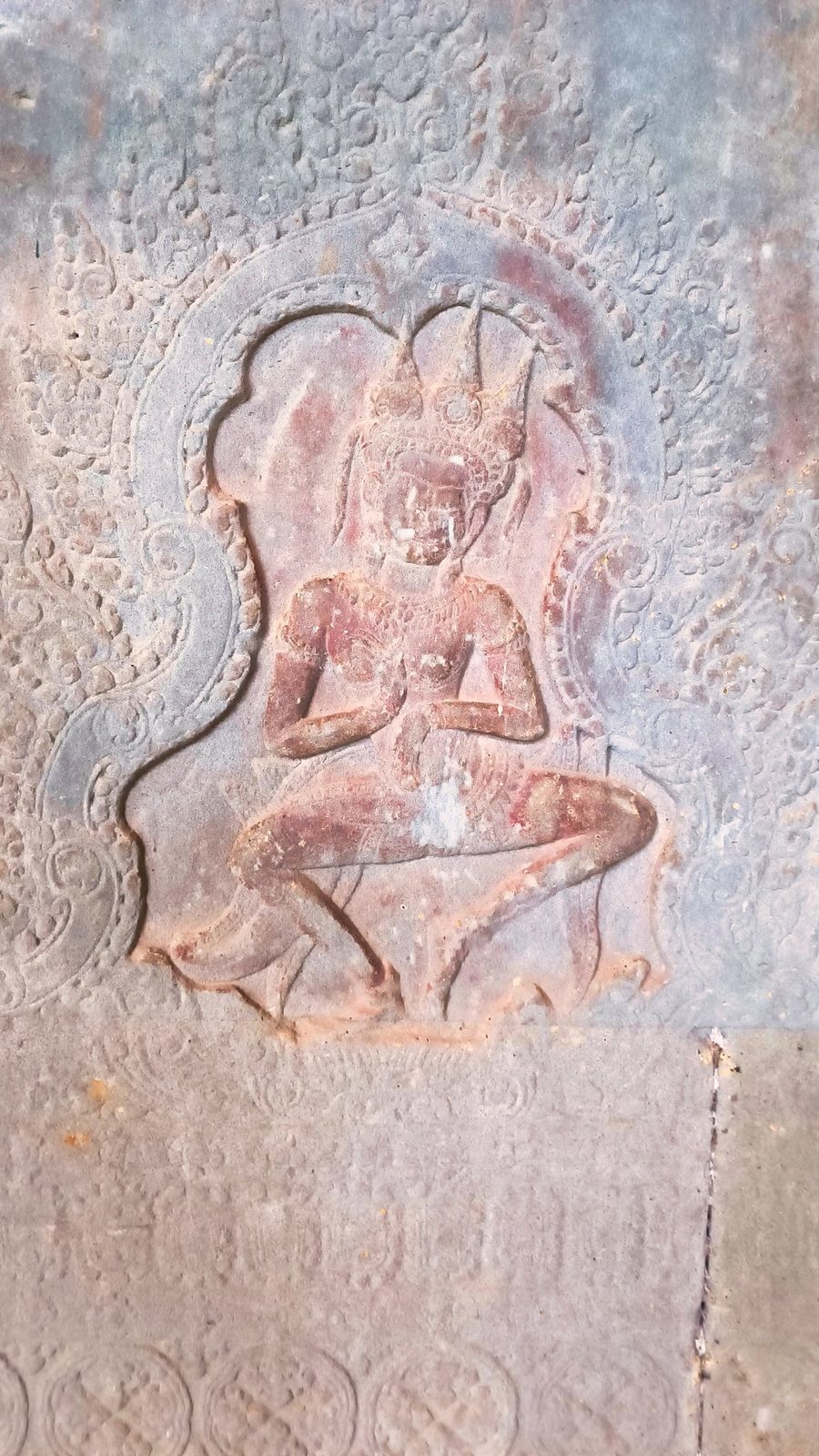 A carved apsara dancer in a niche relief at Angkor Wat