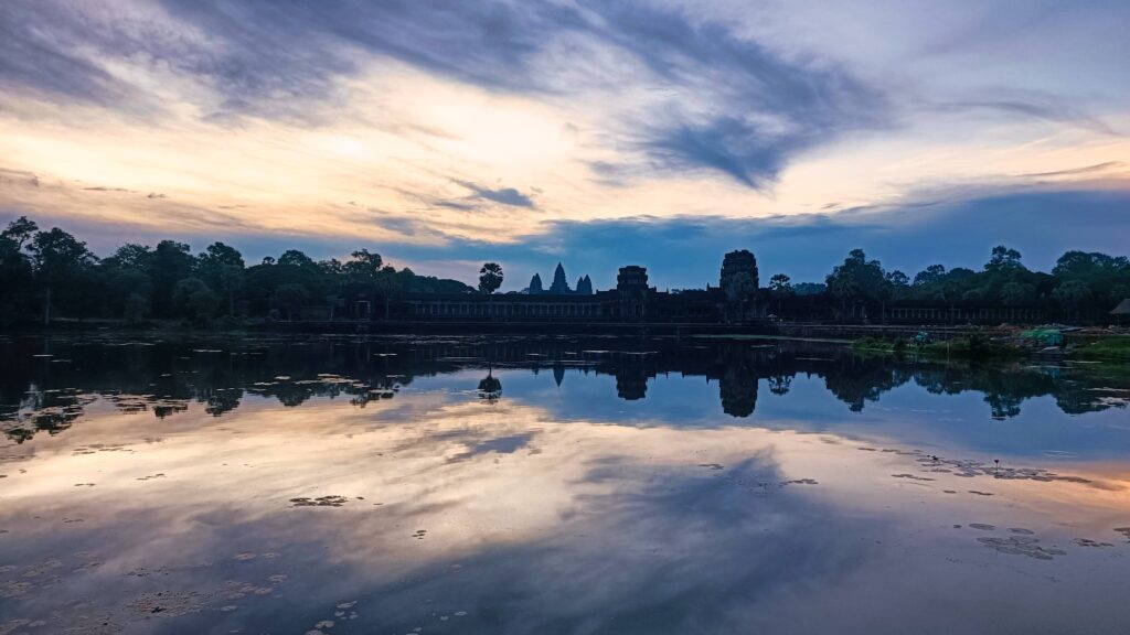 Angkor Wat's five towers reflected in still water at dawn