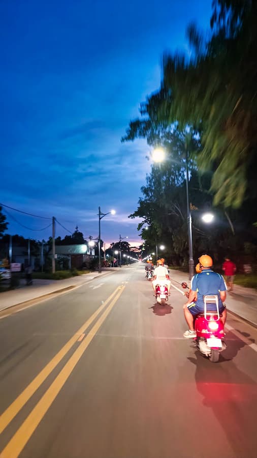 Vespa convoy rolling toward Angkor Wat before sunrise