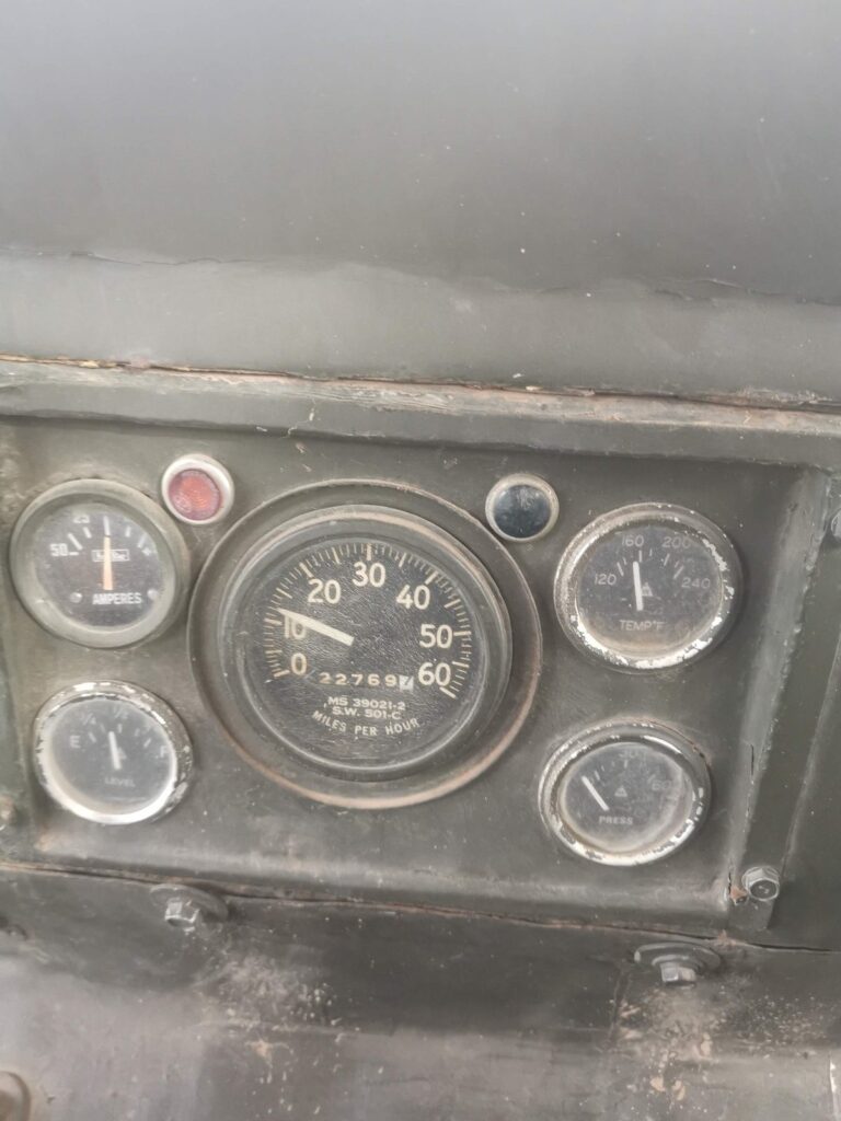 Gros plan d'un compteur de vitesse de jeep Willys vintage et de jauges de tableau de bord.