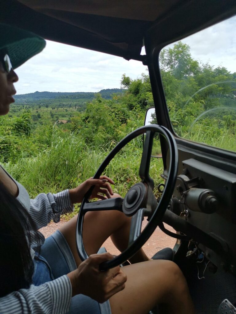 Uitzicht door een vintage jeep voorruit op een landweg in Phnom Kulen.