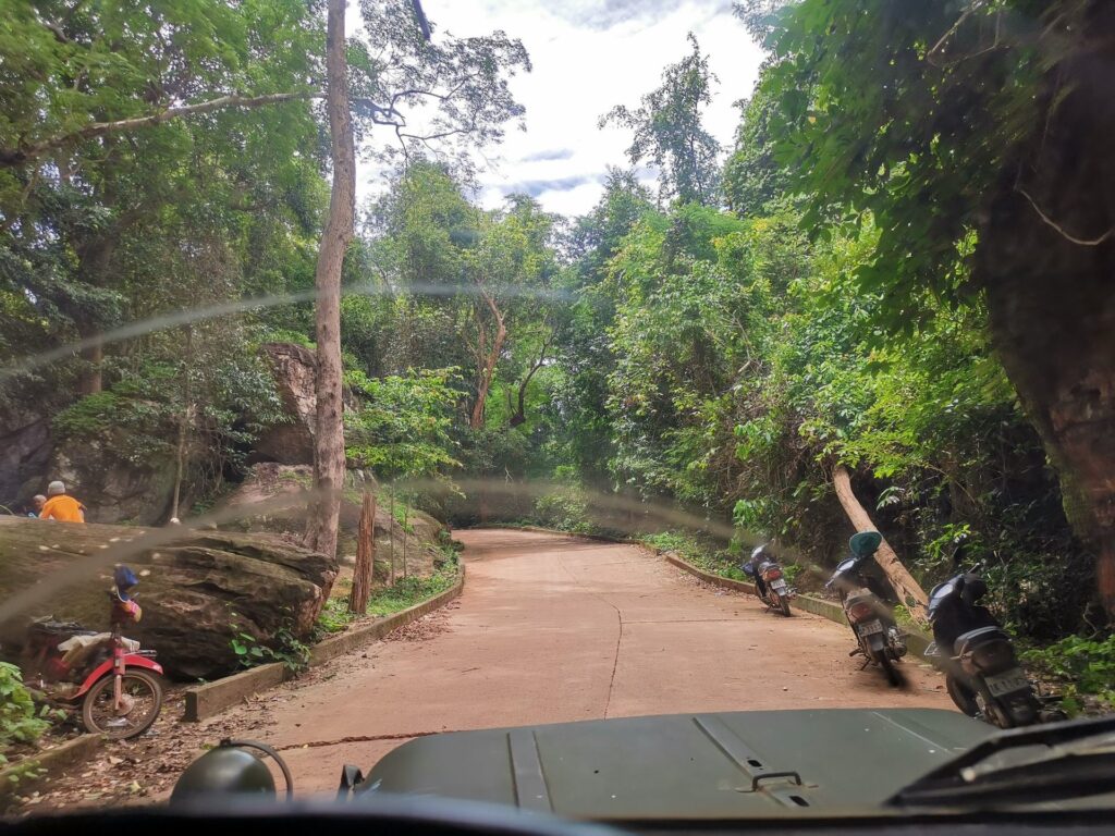 Jeep vintage sur une route forestière montant vers Phnom Kulen.