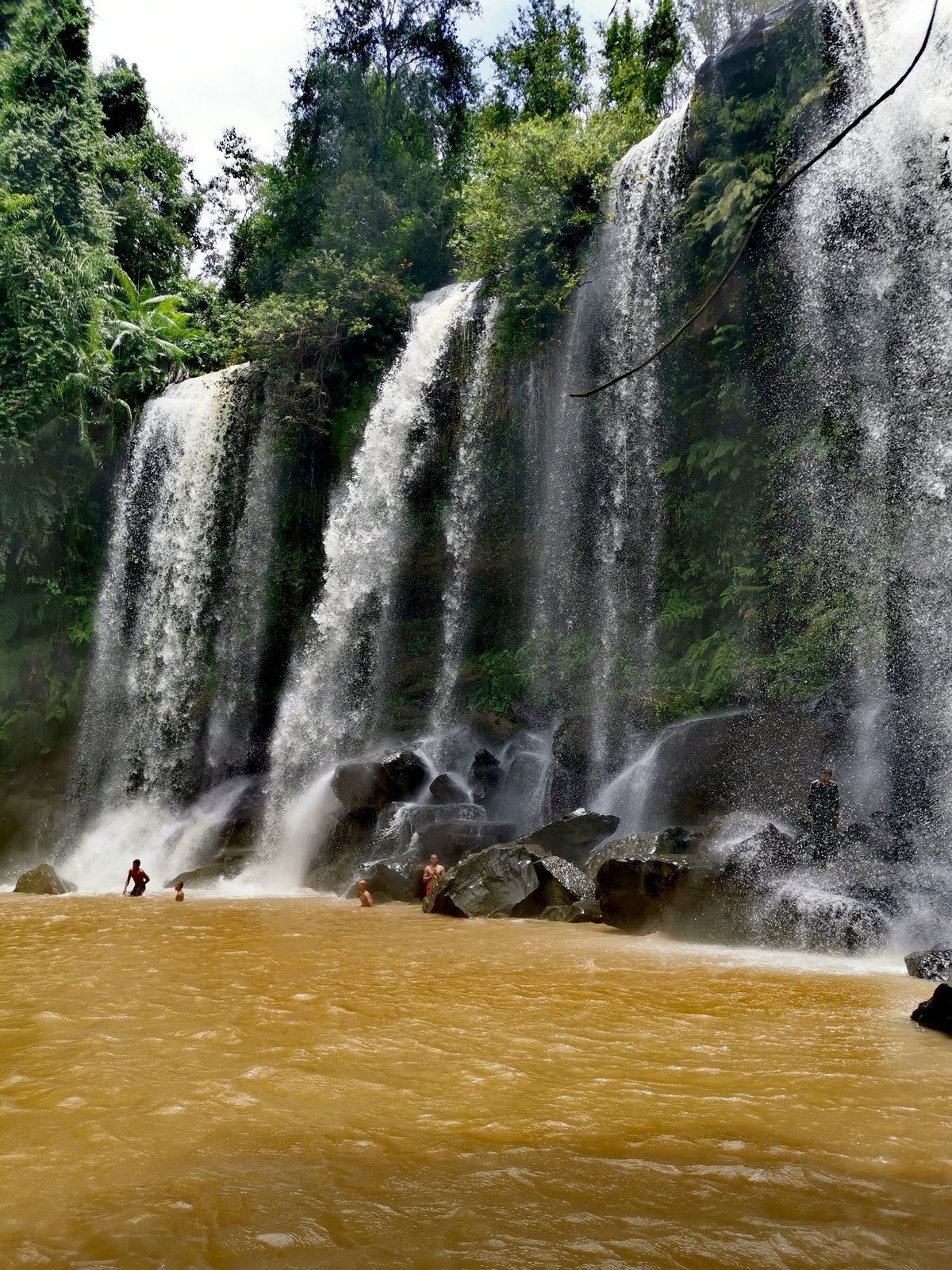 Swimmers in the natural pool below the Phnom Kulen waterfall