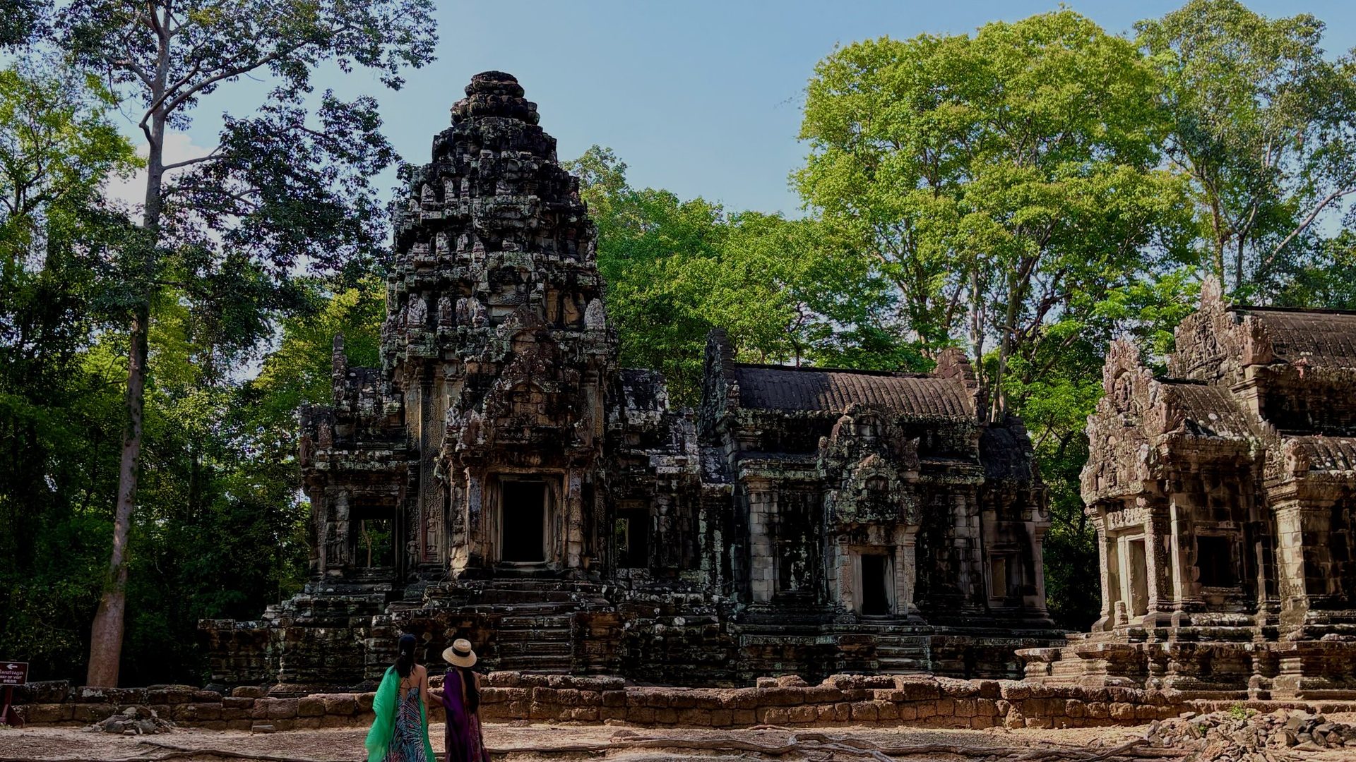 Bezoekers in groene en paarse Khmer-gewaden bij de Thommanon tempel, Angkor
