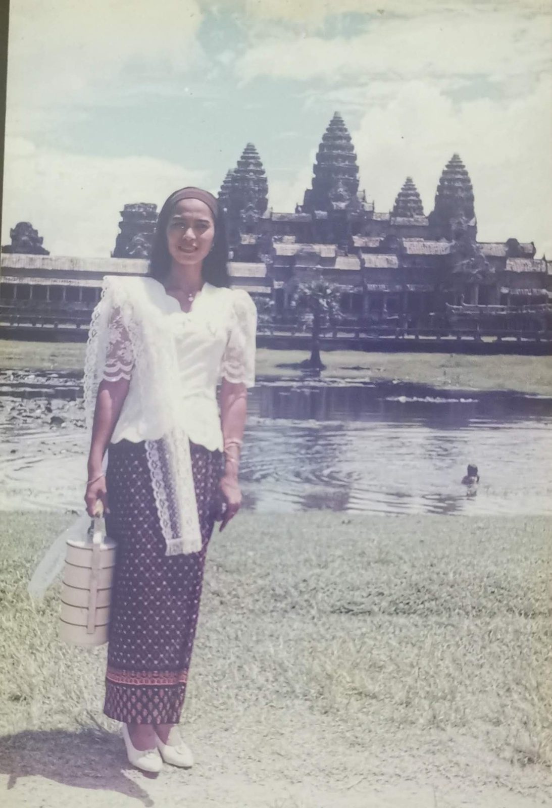 Akim Ly as a young adult with Angkor Wat in the background across the moat