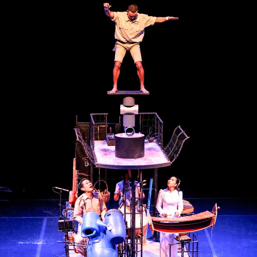 An acrobat balances above the stage at Phare, The Cambodian Circus in Siem Reap, with live Khmer musicians below