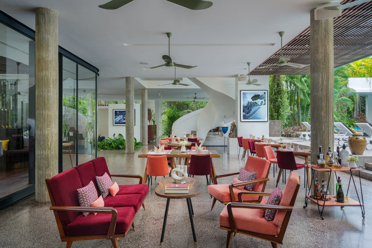 Viroth's 1950s-style lounge and restaurant with crimson and coral velvet chairs, green ceiling fans and terrazzo floor