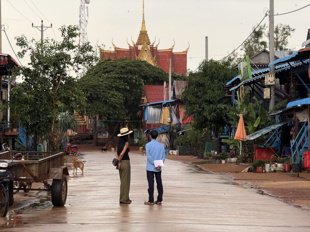 Akim Ly and village guide Kiri standing in the Kampong Phluk street with the pagoda behind