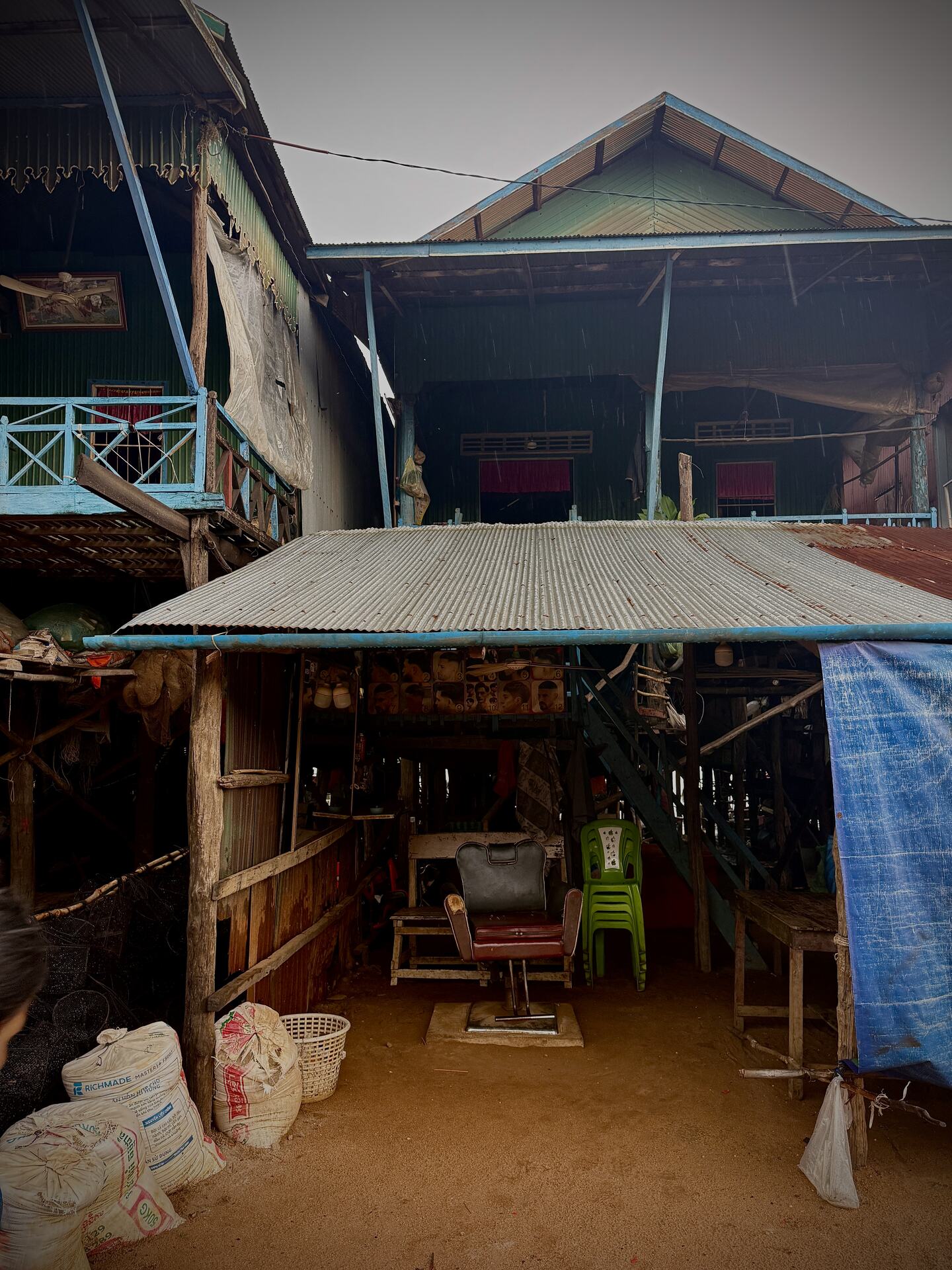 A barber chair set up beneath a stilt house in Kampong Phluk