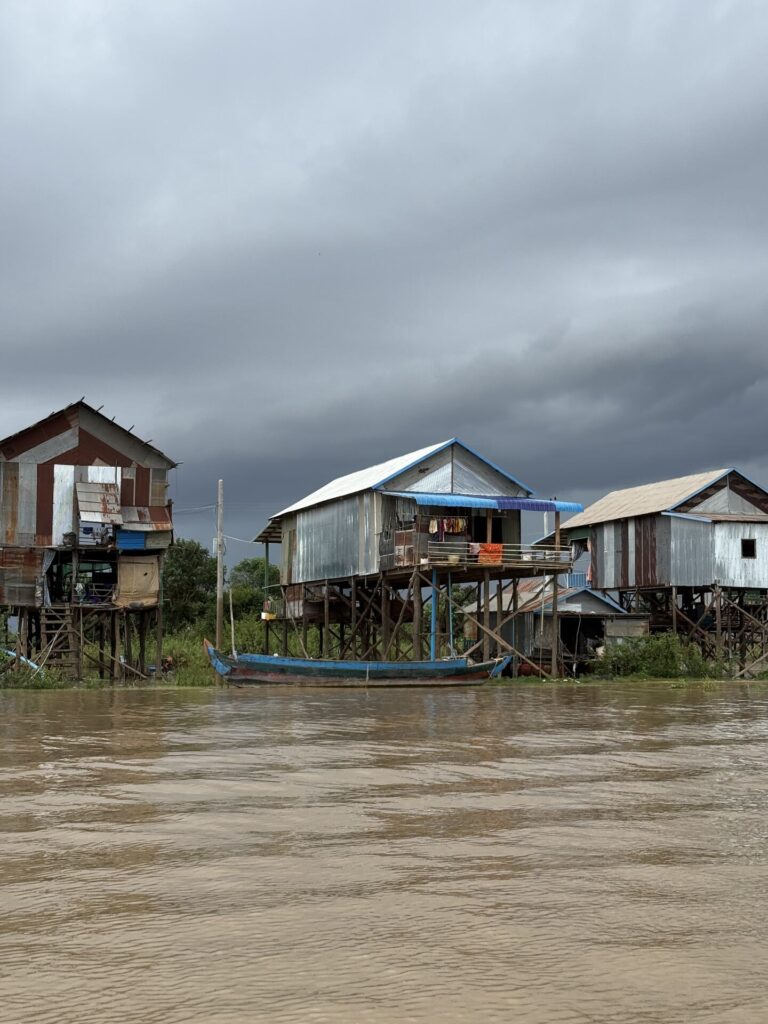 A stilt house with boats beneath it at high water in Kampong Phluk