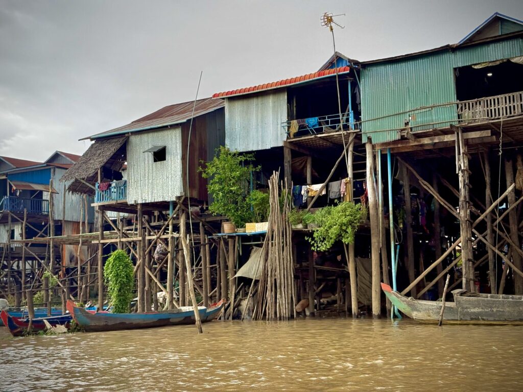 Wooden boats tied below the stilt houses of Kampong Phluk