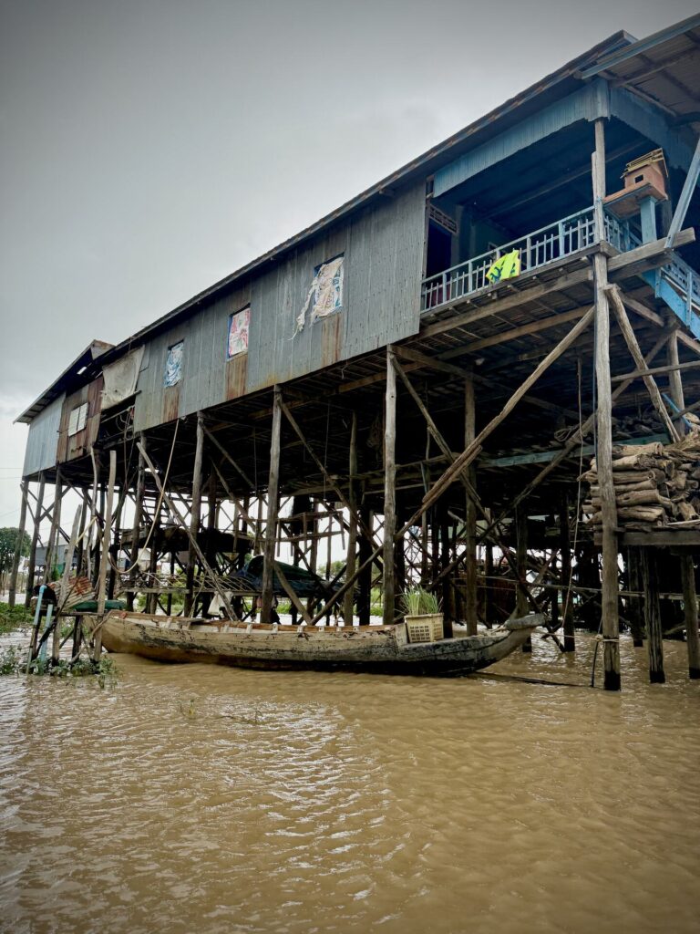 Storm clouds over trees and stilt houses at the edge of Kampong Phluk
