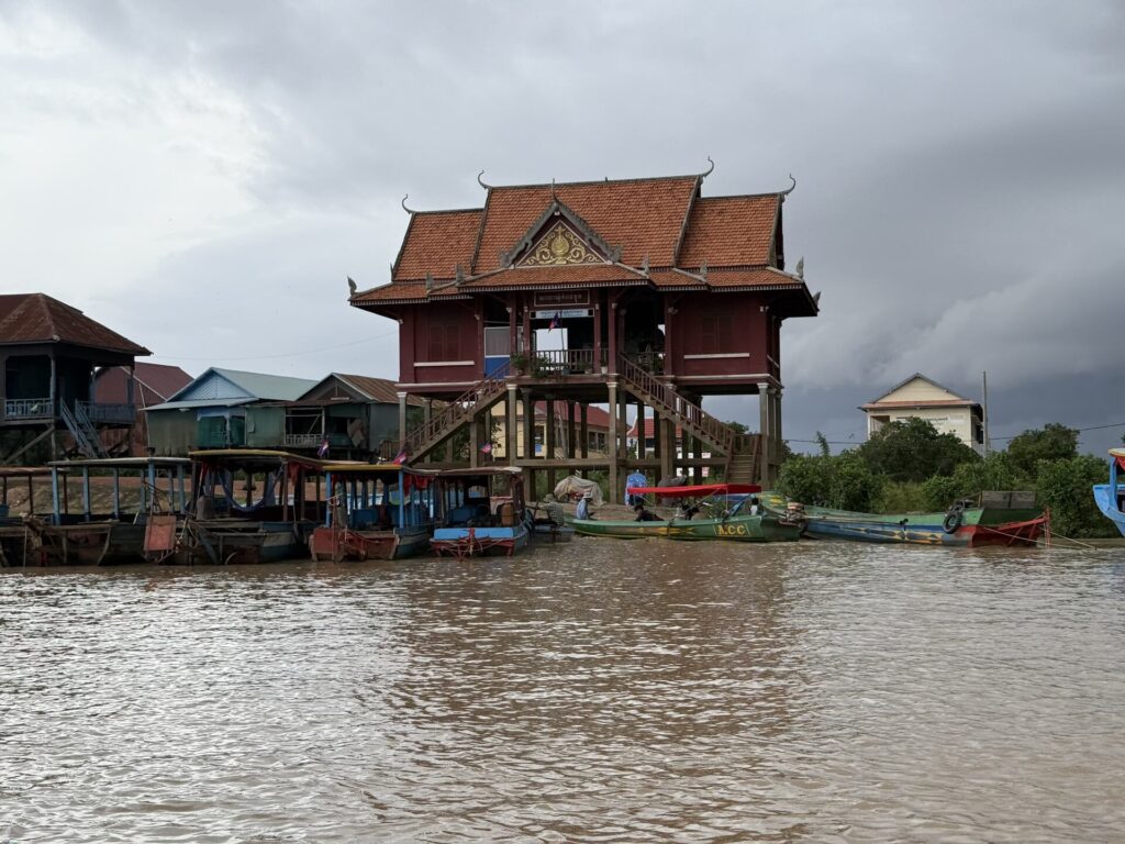 A temple-roofed building above the boats at the Kampong Phluk landing