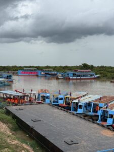 Tour boats moored at the Kampong Phluk landing under monsoon clouds