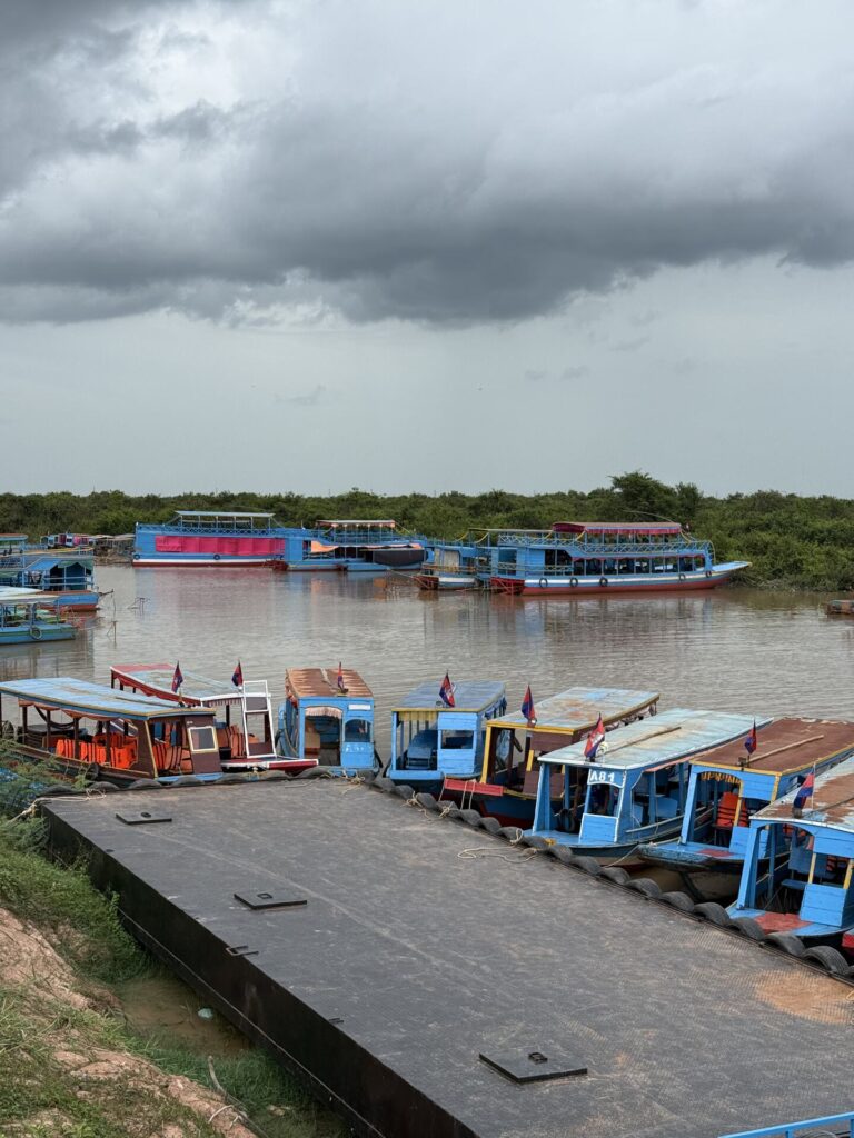 Tour boats moored at the Kampong Phluk landing under monsoon clouds
