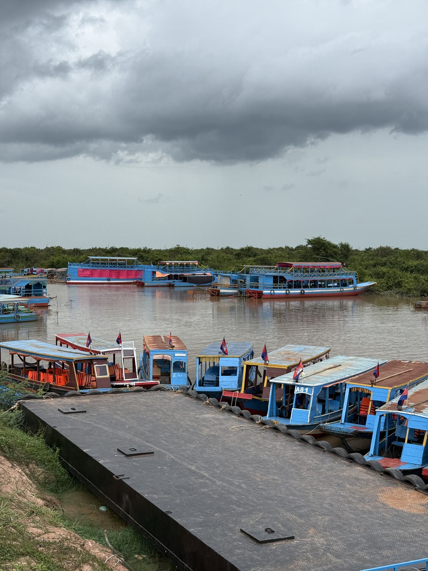Tour boats moored at the Kampong Phluk landing under monsoon clouds