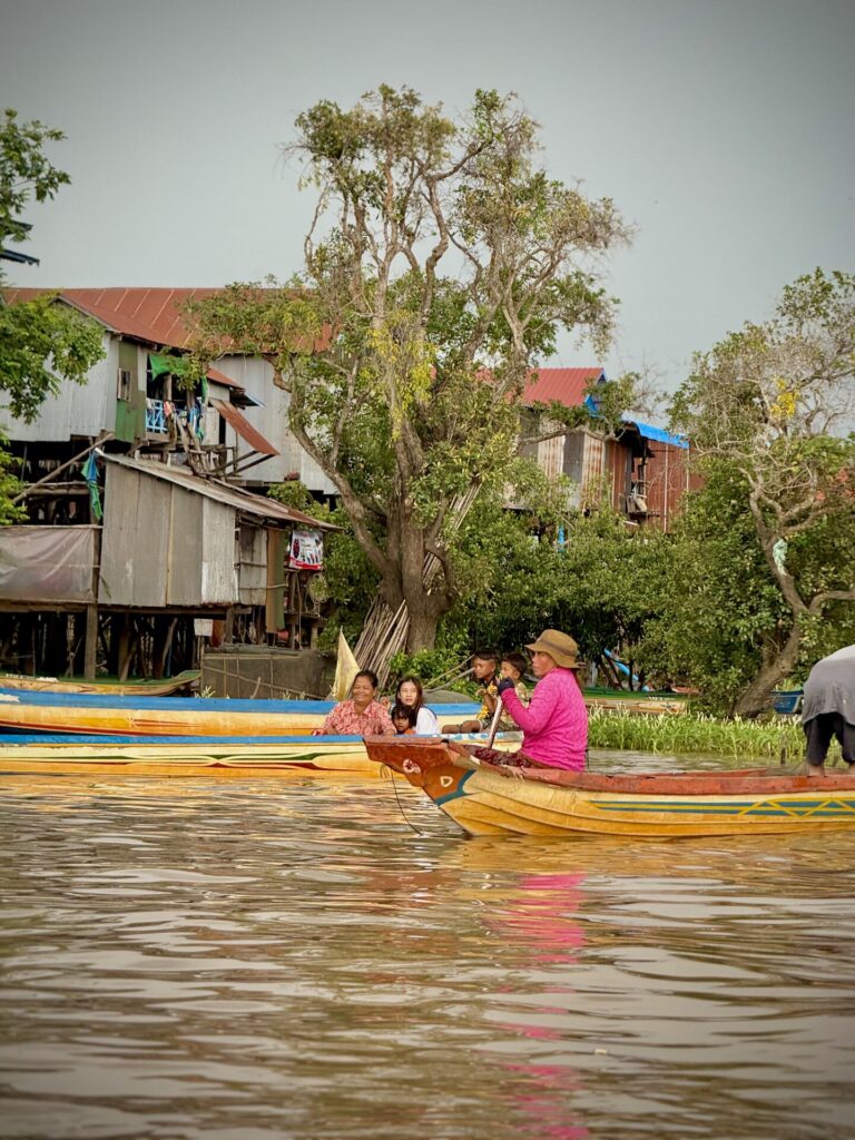 A family rowing home past the stilt houses of Kampong Phluk