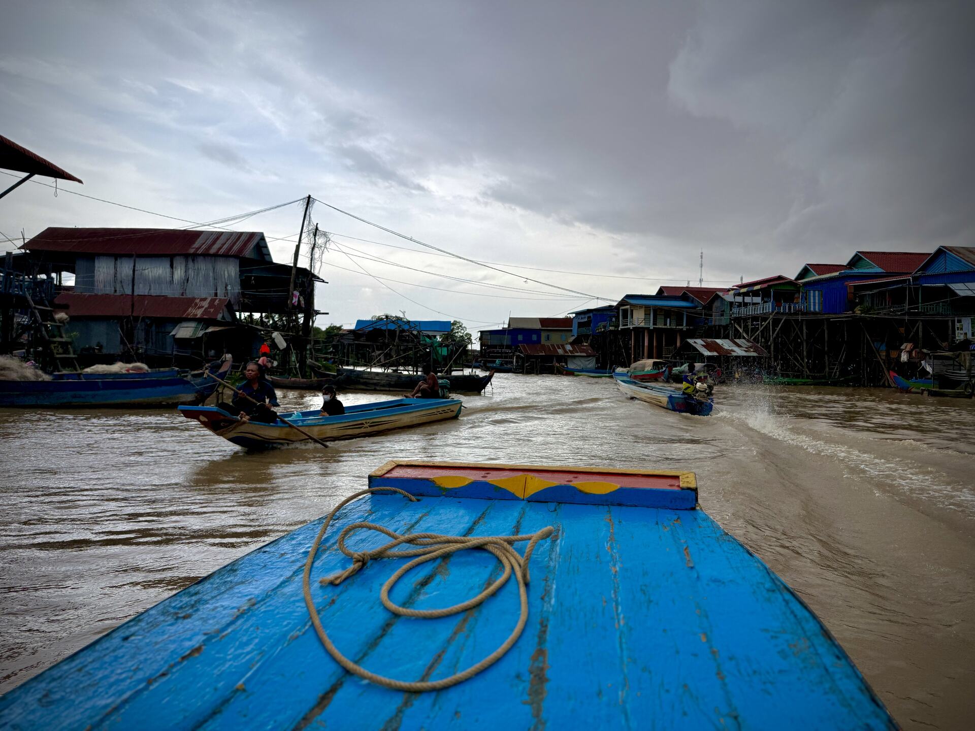 Looking down the Kampong Phluk village channel from the bow of a private boat, stilt houses on both sides