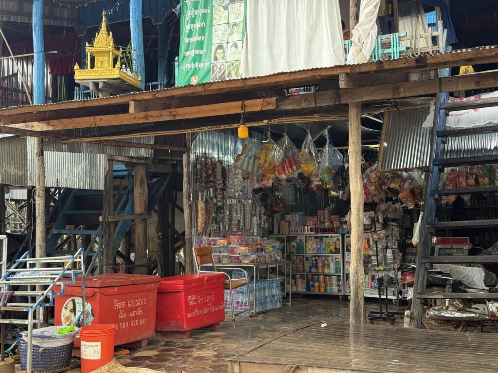 A small shop stocked with goods beneath a stilt house in Kampong Phluk