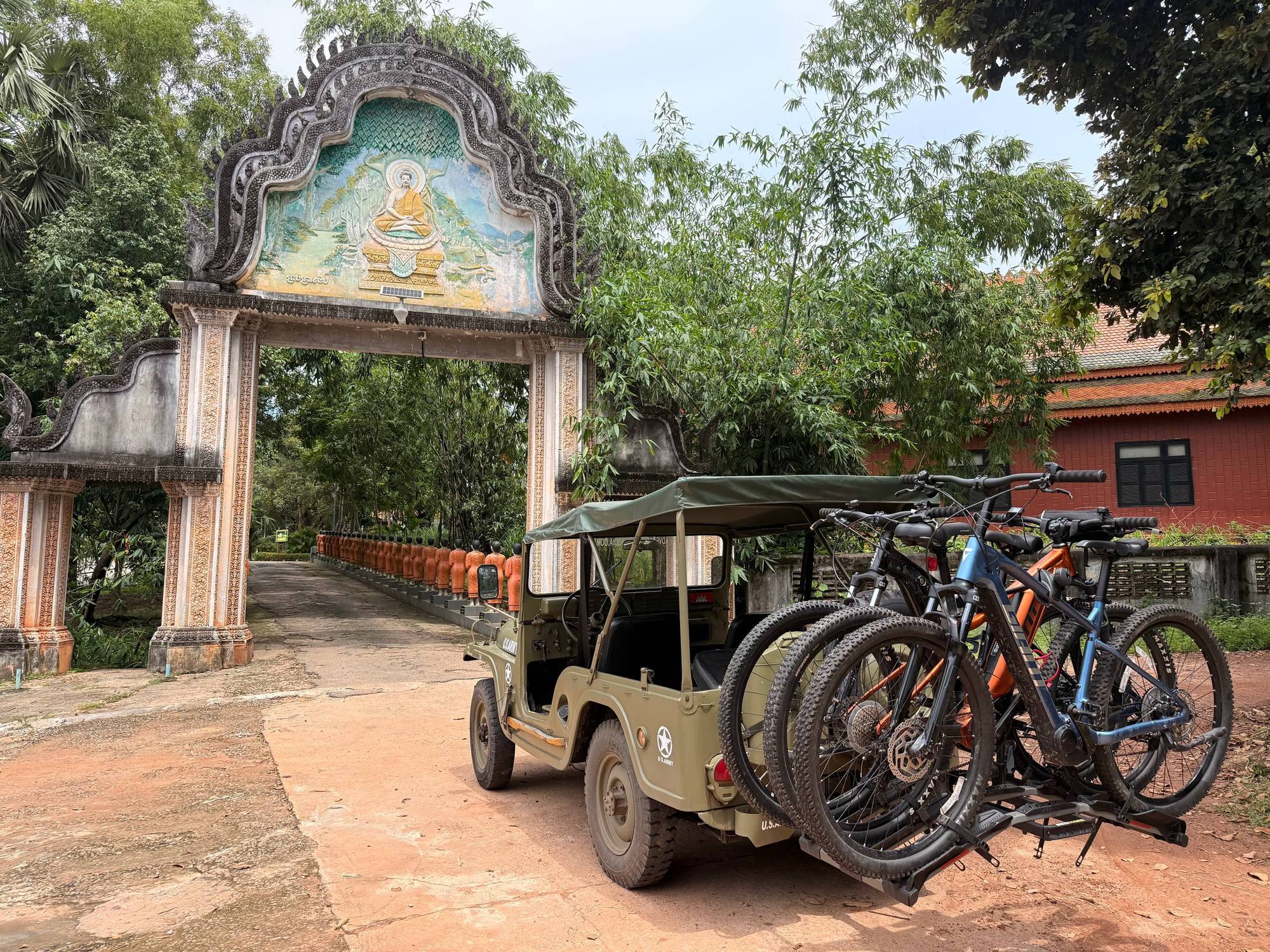 The Jeep parked with bikes on the rack beside a painted pagoda gate