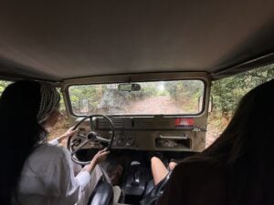 A guest drives the Jeep herself down a countryside track, sides open